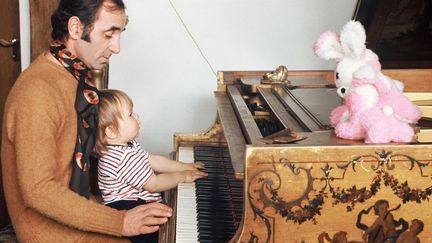 Charles Aznavour au piano avec sa petite Katia en 1971 à Montfort-L'Amaury.
 (Ginies/SIPA)