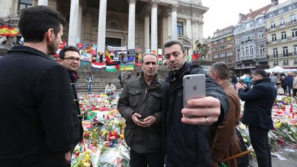 Des personnes se sont réunies sur la place de Bourse à Bruxelles pour un hommage aux victimes, le 27 mars 2016. (NICOLAS MAETERLINCK / BELGA / AFP)