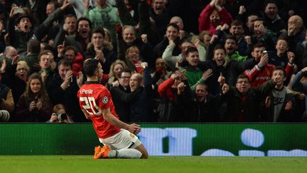 L'attaquant de Manchester United Robin Van Persie f&ecirc;te son tripl&eacute; avec le public d'Old Trafford, lors du match contre l'Olympiakos Le Pir&eacute;e, le 18 mars 2014.&nbsp; (PAUL ELLIS / AFP)