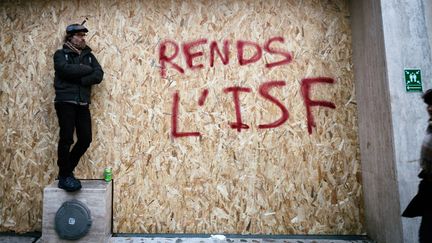 Un tag contre la suppression de l'impôt sur la fortune (ISF), lors d'une manifestation contre la réforme des retraites, le 10 décembre 2019 à Paris.&nbsp; (MARTIN NODA / HANS LUCAS / AFP)