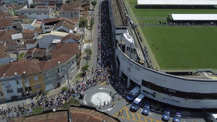 Des centaines de Brésiliens patientent en ligne devant le stade Urbano Caldeira pour rendre hommage à Pelé, le 2 janvier 2023. (MIGUEL SCHINCARIOL / AFP)