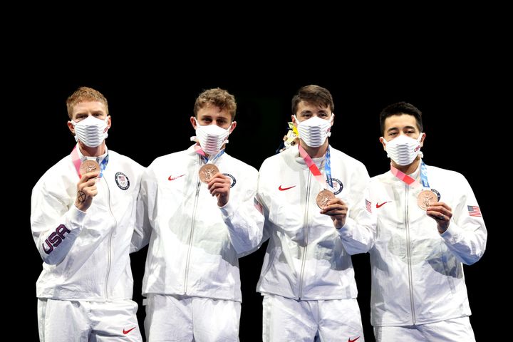 La remise de la médaille de bronze à l'équipe américaine de fleuret, le 1er août 2021, aux JO de Tokyo. Race Imboden, le premier escrimeur à gauche, a dessiné une croix sur sa main, en soutien aux opprimés. (ELSA / GETTY IMAGES ASIAPAC)