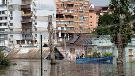 Des habitants évacuent un quartier inondé de Kherson (Ukraine), le 8 juin 2023, deux jours après la destruction du barrage de Kakhovka qui a entraîné d'immenses inondations en aval. (ALEKSEY FILIPPOV / AFP)