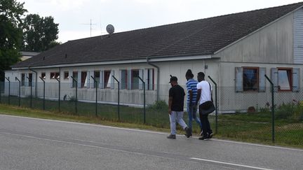 Des réfugiés devant un centre de transit de Manching, en Allemagne. (CHRISTOF STACHE / AFP)