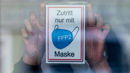 Une affiche sur le port du masque en Allemagne, le 3 novembre 2021. (ARMIN WEIGEL / DPA / AFP)