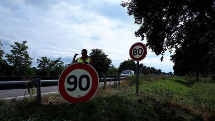 Deux agents procèdent au changement de panneaux de vitesse de 80 à 90 km/h, dans le Haut-Rhin, en 2018 (photo d'illustration). (PATRICK GENTHON / RADIO FRANCE)