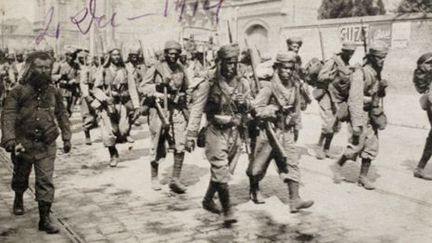 Carte postale montrant des tirailleurs maghrébins marchant dans les rues d'Amiens en 1914 (AFP - STR - Historial de Péronne)