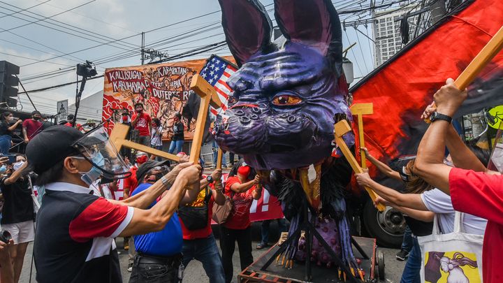 Des manifestants détruisent une effigie représentant le président philippin Rodrigo Duterte lors d'une manifestation pour marquer la fête du Travail à Manille, le 1er mai 2021. (MARIA TAN / AFP)