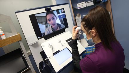 Une&nbsp;femme participe à une&nbsp;téléconsultation depuis une pharmacie à Montbéliard (Franche-Comté), le 3 février 2021. (MAXPPP)