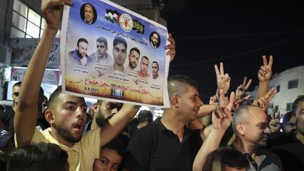 Des Palestiniens brandissent les portraits des six détenus et&nbsp;fêtent leur évasion dans un camp de réfugiés à Jénine, en Cisjordanie occupée, le 6 septembre 2021. (JAAFAR ASHTIYEH / AFP)