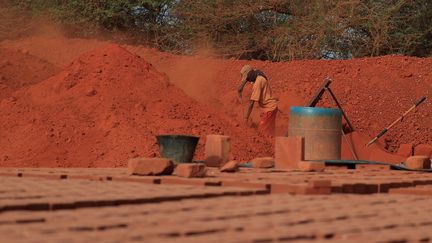 Un ouvrier sépare la terre crue et les roches à Elementerre, une entreprise spécialisée dans brique en terre compressée, le 10 mai 2021, Mbour, Sénégal. (ZOHRA BENSEMRA - REUTERS)