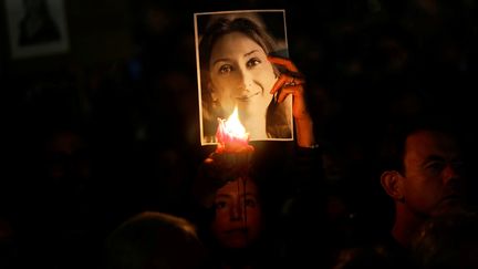 Une manifestante éclaire à la bougie une photo de la journaliste Daphne Caruana Galizia lors d'un rassemblement pour le deuxième anniversaire de l'assassinat de la journaliste, le 16 octobre 2019 à La Valette (Malte). (DARRIN ZAMMIT LUPI / REUTERS)