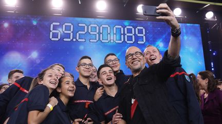 Le chanteur Pascal Obispo, parrain de la 32e édition, pose avec des pompiers lors du Téléthon, le 9 décembre 2018 à Paris. (GILLES SCARELLA / FRANCE TELEVISIONS)