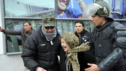 Une femme âgée, touchée par des gaz lacrymogènes, est entraînée à l'écart d'une manifestation à Tunis, le 6 février 2013, à la suite de l'assassinat du responsable de l'opposition, Chokri Belaïd. (AFP - FETHI BELAID )