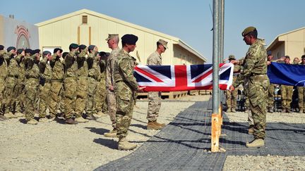 Des soldats britanniques baissent leur drapeau sur la base militaire de Camp Bastion, dans la r&eacute;gion du Helmand, en Afghanistan, le 26 octobre 2014. (SERGEANT OBI IGBO / CROWN COPYRIGHT 2014 / AFP)