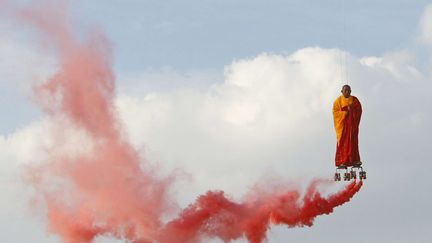 L'artiste chinois Li Wei fait une performance suspendu dans les airs au dessus de La Villette &agrave; Paris, le 20 mars 2012. (FRANCOIS MORI / AP / SIPA)