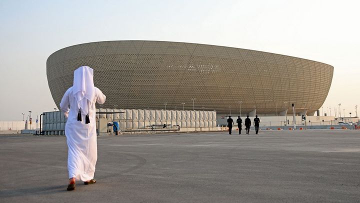 Un homme devant le stade Lusail, qui accueillera jusqu'à 80 000 supporters pour la Coupe du monde au Qatar entre novembre et décembre 2022. (MUSTAFA ABUMUNES / AFP)