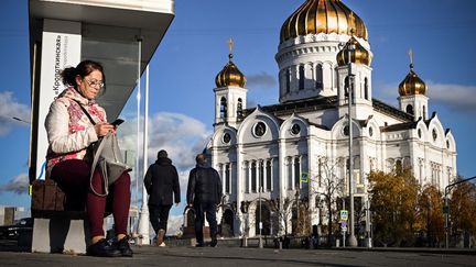 Une femme devant la Cathédrale du Christ Sauveur à Moscou (Russie), le 18 octobre 2021. (ALEXANDER NEMENOV / AFP)