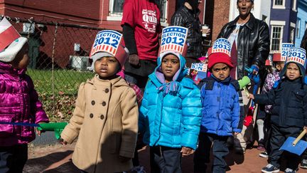 Des enfants d&eacute;filent devant l'&eacute;cole de Dunbar&nbsp;&agrave; Washington. (BRENDAN HOFFMAN / GETTY IMAGES)