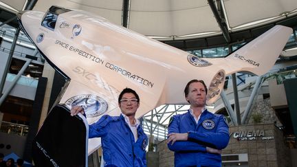 Des dirigeants de SXC devant une navette de la compagnie n&eacute;erlandaise, en juillet 2013, &agrave; Hong Kong (Chine). (PHILIPPE LOPEZ / AFP)