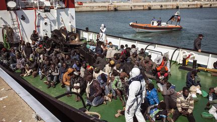 &nbsp; (Des migrants récupérés par un cargo accostent dans un port italien à Corigliano. © Maxppp)