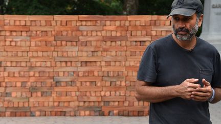 L'artiste mexicain Bosco Sodi devant son "Muro", mur de briques qu'il a construit symboliquement pour protester contre les projets de Donald Trump (7 septembre 2017)
 (Timothy A. Clary / AFP)