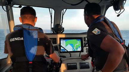 Les gendarmes Ludovic (à gauche) et Mohamedi (à droite), face à l'écran de contrôle du navire de la brigade nautique de Mayotte. (SANDRINE ETOA-ANDEGUE)