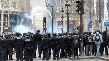 Des policiers tentent de disperser la foule de manifestants sur l'avenue des Champs-Elysées, lors de la 18e journée de mobilisation des "gilets jaunes". (MAXPPP)