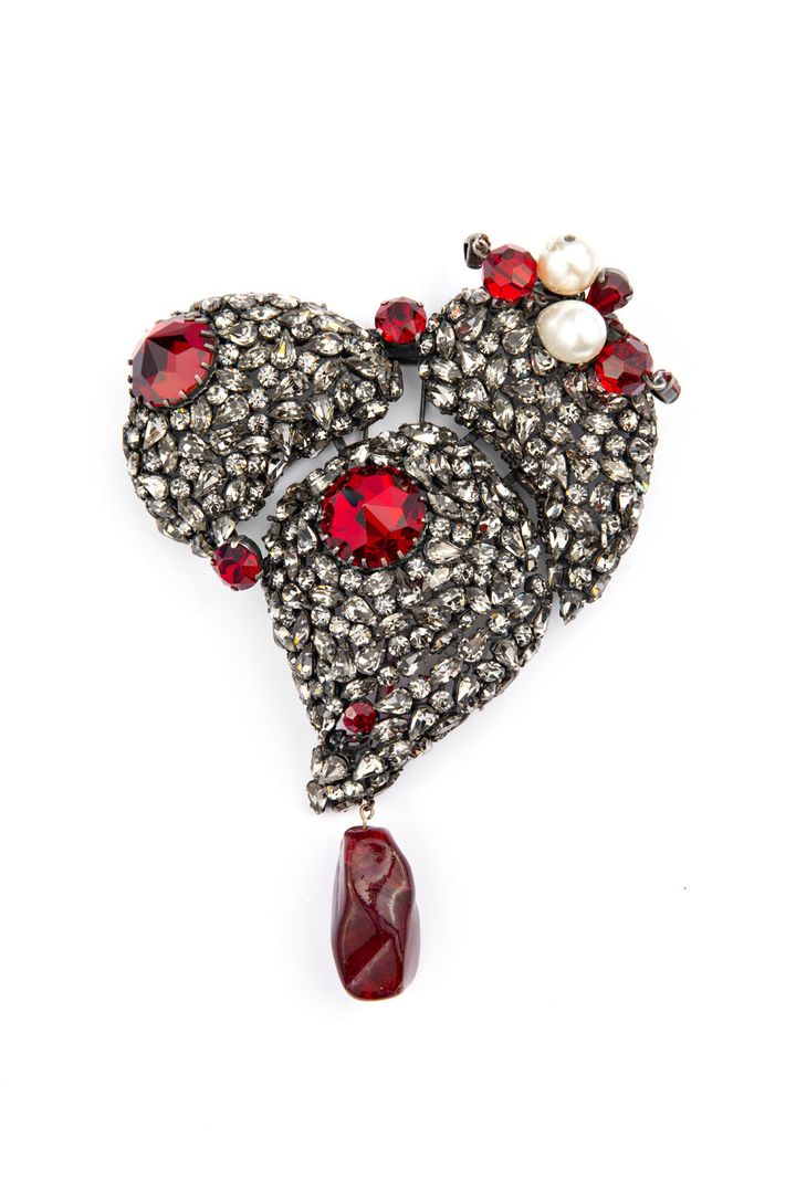 Coeur Yves Saint Laurent en strass gris fumé, cabochons en cristal rouge, perles blanches et pâte de verre conçu en 1962 et réédité en 1979 (maison Scemama).&nbsp;Collection Musée Yves Saint Laurent Paris. Ce coeur est exposé au musée du Louvre&nbsp;dans le cadre de l'exposition&nbsp;"Yves Saint Laurent aux musées" (© Yves Saint Laurent @ Nicolas Mathéus)