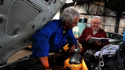 Des seniors travaillent dans un garage automobile. (MYCHELE DANIAU / AFP)