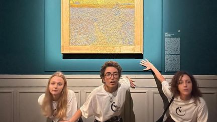 Des&nbsp;activistes climatiques de Last Generation posant, le 4 novembre 2022, près du tableau&nbsp;"Le semeur" de&nbsp;l'artiste néerlandais Vincent Van Gogh, après qu'ils lui aient jeté de la soupe aux pois au palais Bonaparte, à Rome, en Italie. (STRINGER / ANSA)