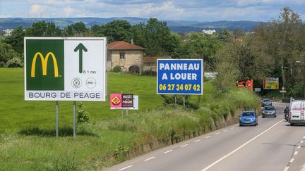 Des affiches d'enseignes commerciales sur des panneaux publicitaires grand format en bordure de route nationale a l'entrée de Bourg-de-Péage (Drôme), le 7 mai 2021. (NICOLAS GUYONNET / HANS LUCAS / AFP)