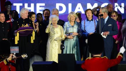 La reine Elizabeth II salue la foule sur sc&egrave;ne apr&egrave;s un concert pop g&eacute;ant &agrave; Londres (Grande-Bretagne) &agrave; l'occasion de son jubil&eacute; de diamant, le 4 juin 2012. (LEON NEAL / AFP)