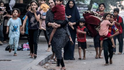 Des femmes palestiniennes et leurs enfants fuient les frappes israéliennes sur la bande de Gaza (Palestine), le 11 octobre 2023. (MOHAMMED ABED / AFP)