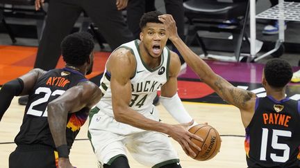 La star Giannis Antetokounmpo au coeur de la défense de Phoenix, face à&nbsp;Deandre Ayton et&nbsp;Cameron Payne, lors du match 5 à Phoenix des Finales de NBA. (MATT YORK / AP)