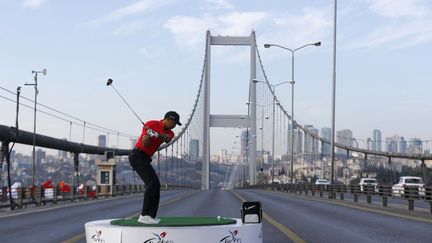 Le golfeur am&eacute;ricain Tiger Woods tente d'envoyer une balle de golf en Europe depuis le pont du Bosphore qui relie Istanbul au vieux continent, le 5 novembre 2013. (MURAD SEZER / REUTERS)