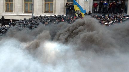 Les policiers anti-&eacute;meutes sont cach&eacute;s derri&egrave;re un &eacute;pais nuage de fum&eacute;e, devant les bureaux pr&eacute;sidentiels, &agrave; Kiev, samedi 1er d&eacute;cembre 2013.&nbsp; (VASILY MAXIMOV / AFP)