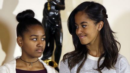 Sasha et Malia Obama&nbsp;lors de la traditionnelle gr&acirc;ce accord&eacute;e &agrave; une dinde pour la f&ecirc;te de Thanksgiving, le 27 novembre 2014 &agrave; la Maison Blanche, &agrave; Washington.&nbsp; (GARY CAMERON / REUTERS)