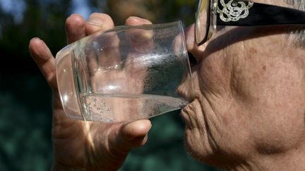 A woman drinks a glass of water in Hyères (Var), July 10, 2023. (MAGALI COHEN / HANS LUCAS / AFP)