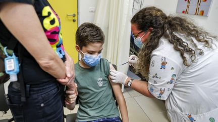 Un enfant reçoit une injection d'un vaccin contre le Covid-19 à Holon, en Israël, le 21 juin 2021. (JACK GUEZ / AFP)