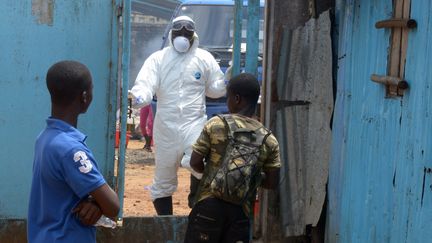 Des proches de personnes contamin&eacute;es par le virus Ebola attendent devant l'entr&eacute;e d'une zone &agrave; haut risque de l'h&ocirc;pital John-Fitzgerald-Kennedy de Monrovia (Liberia), le 3 septembre 2014. (DOMINIQUE FAGET / AFP)