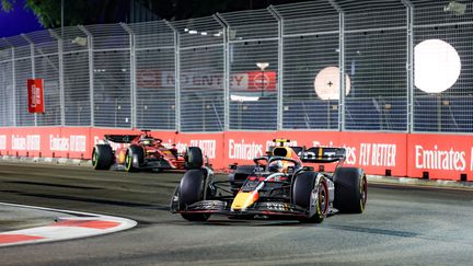 Sergio Pérez (Red Bull), talonné par Charles Leclerc&nbsp;(Ferrari), lors du Grand Prix de Singapour, le 2 octobre 2022, sur le circuit Marina Bay.&nbsp; (FLORENT GOODEN / AFP)