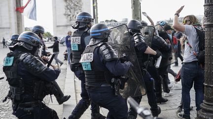 Des gendarmes chargent des manifestants, près de l'Arc de triomphe, le 14 juillet 2019, sur les Champs-Elysées à Paris. (KENZO TRIBOUILLARD / AFP)