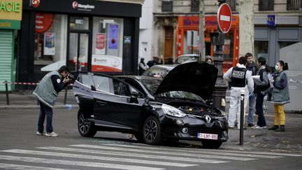 Des policiers examinent le véhicule suspect retrouvé dans le 18e arrondissement de Paris, le 17 novembre 2015. (KENZO TRIBOUILLARD / AFP)