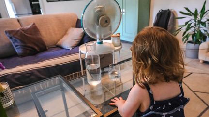 Une enfant de deux ans se rafraichit devant un ventilateur pendant une vague de chaleur, à Valence (Drôme), le 15 juin 2022. (NICOLAS GUYONNET / HANS LUCAS / AFP)