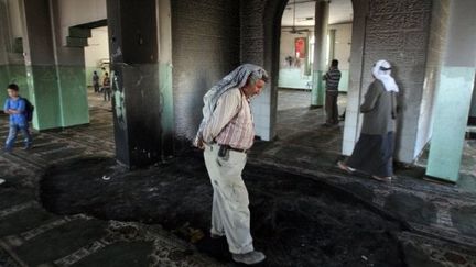 Un Palestinien inspecte la mosquée d'Al-Moughayer qui a été partiellement incendiée à l'aube (7/6/2011) (AFP / Abbas Momani)