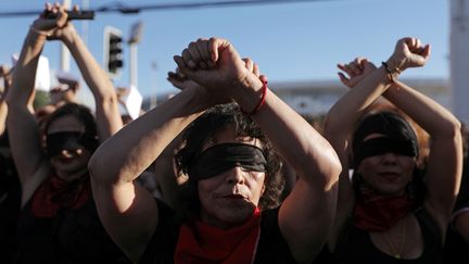 Des activistes féministes interprètent "Un violador en tu camino" ("Un violeur sur ton chemin"), le 4 décembre 2019 dans les rues de Santiago (Chili).&nbsp;Créée pour manifester contre les violations des droits des femmes dans le cadre des manifestations antigouvernementales au Chili, cette performance a ensuite été adaptée dans de nombreux pays du monde. (PABLO SANHUEZA / REUTERS)