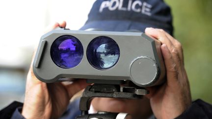 Un policier effectue, &agrave; l'aide d'un radar, des contr&ocirc;les de vitesse, sur les quais de Bordeaux, le 29 octobre 2011. (JEAN-PIERRE MULLER / AFP)