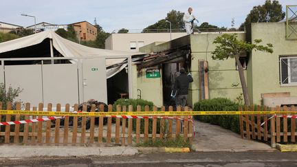 Des&nbsp;personnes inspectent une salle de prière musulmane incendiée à Ajaccio (Corse-du-Sud), le 30 avril 2016. (MAXPPP)