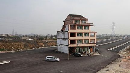 Une « maison clou» dans le milieu d'une route nouvellement construite dans la province de Zhejiang, le 24 novembre 2012. (REUTERS / Aly Song)